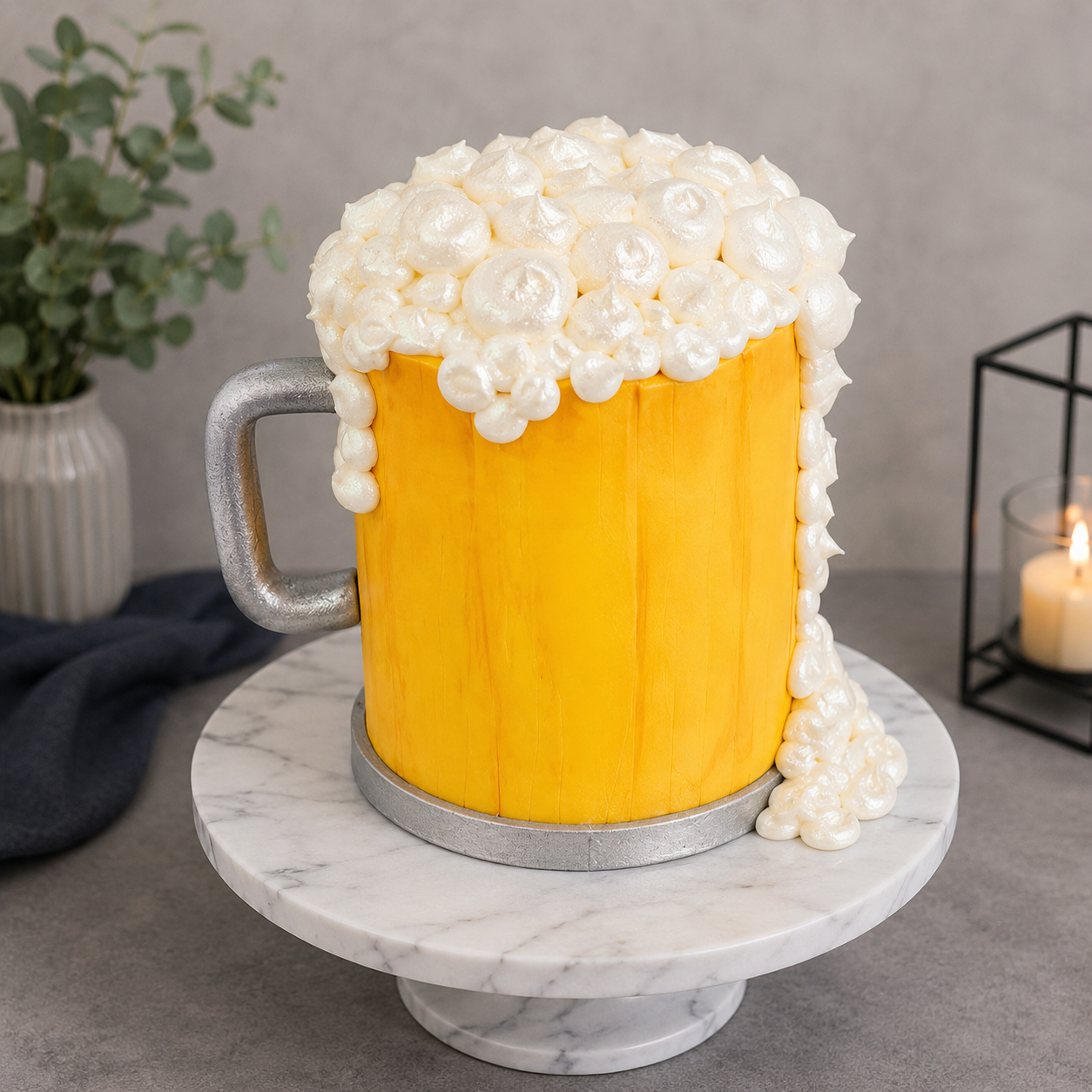 Beer mug cake with white foam on a marble stand against a gray background