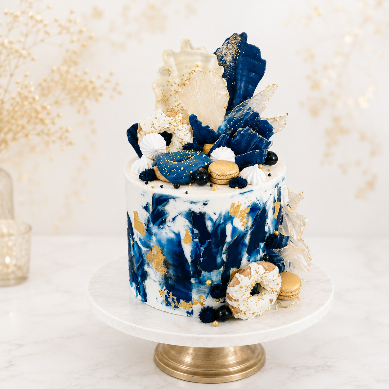 Decorative cake with blue and gold accents on a white stand against a light background