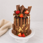 Chocolate cake with strawberries and chocolate bars on a white background