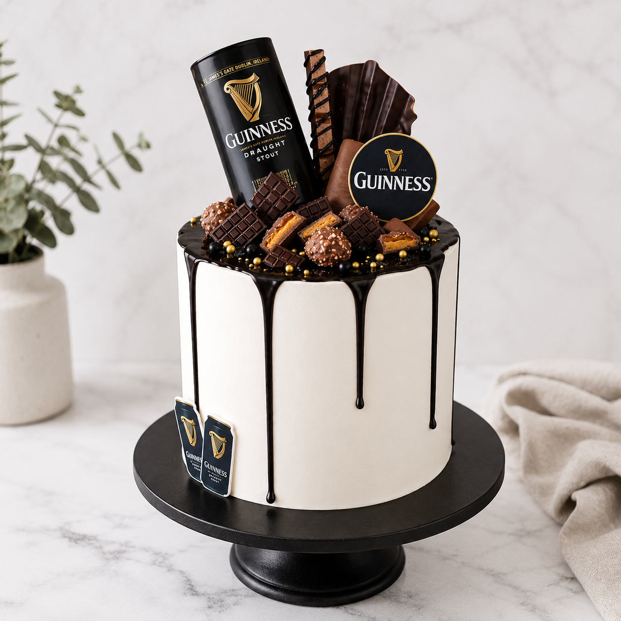 White cake with chocolate decorations and Guinness branding on a marble surface.