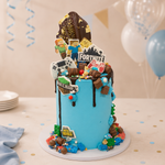 Multimedia-themed birthday cake with game character decorations on a table with balloons.