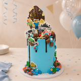 Multimedia-themed birthday cake with game character decorations on a table with balloons.