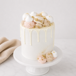 Decorative cake with pink and gold accents on a white stand.