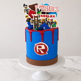 Roblox-themed birthday cake with character figures and colorful design on a white marble surface.