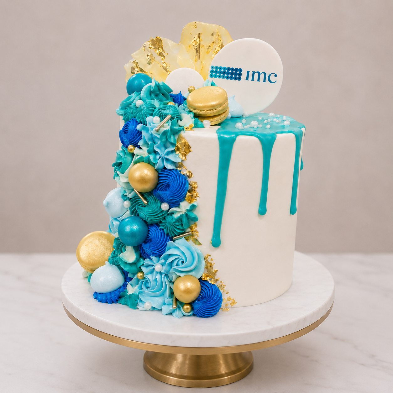 Decorative cake with blue and gold elements on a marble stand against a neutral background